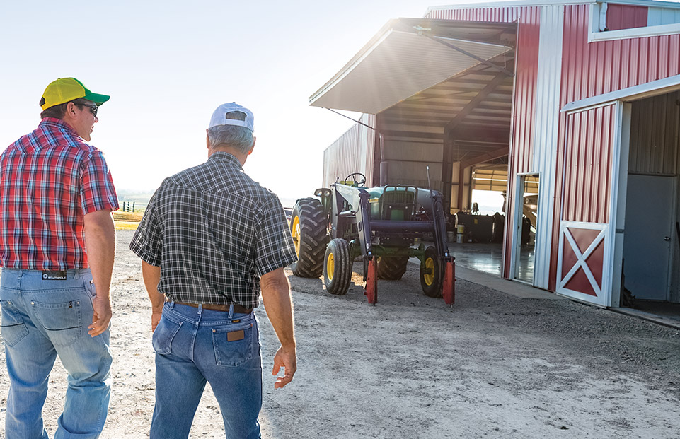 Farmers talking between machinery