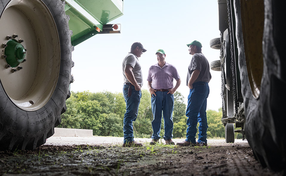 Farmers talking between machinery